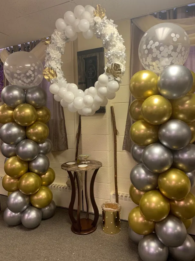 Gold and silver balloon columns with a white floral wreath