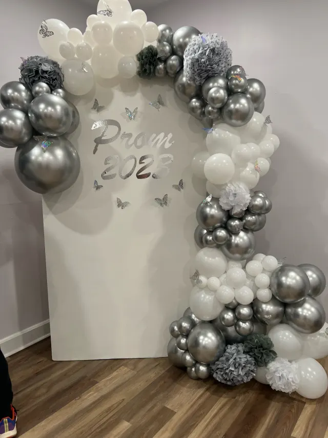 Silver and white prom balloon arch with butterfly accents